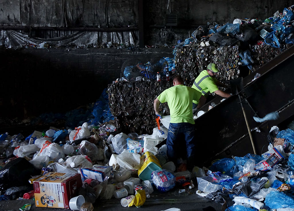 Workers handle and process trash